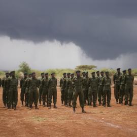Community scouts stand to attention in a field during a training session.