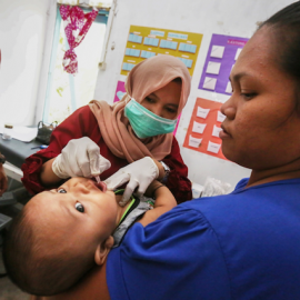 A member of the Health Ambassador program checks out a young child.