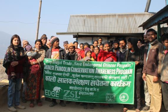 Nepalese villagers hold a banner promoting conservation of the Chinese pangolin.