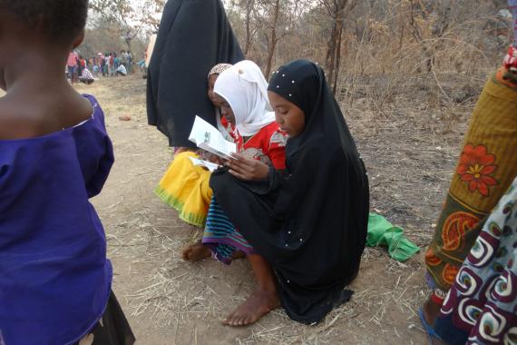 Young Tembo Cup attendees in Kintanula Village read STEP’s human-elephant coexistence booklet.